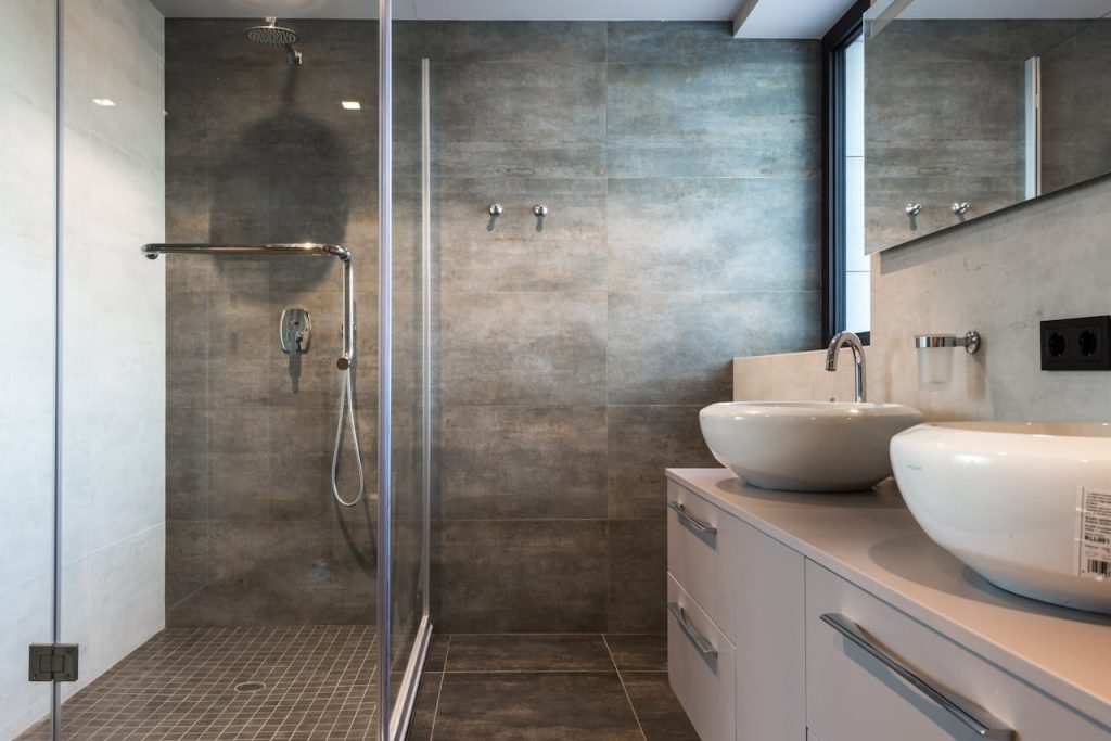 a-ceramic-sink-on-top-of-the-drawer-near-the-shower-room-8134822 Stylish bathroom interior featuring ceramic sinks, glass shower, and elegant finishes.